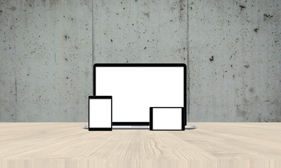 Laptop on office wooden desk with two tablets