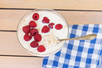 oatmeal with raspberries on a wooden background. breakfast