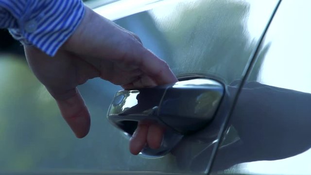 Slowmotion detail of handle of car and woman who gets in 