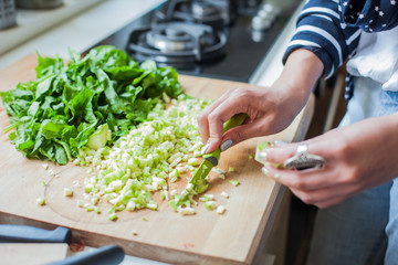 Woman cooking in kitchen with ingredients around her