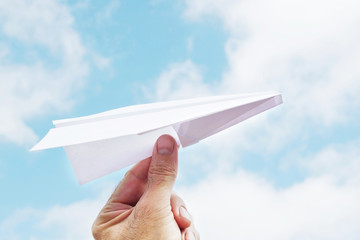 Man throws a paper plane to sky