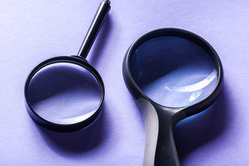 Magnifier on blue background close up