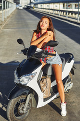 Obraz na płótnie Canvas Portrait of stylish girl on scooter - outdoor fashion portrait