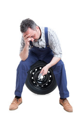 Stressful job concept with exhausted mechanic in overallas