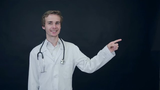 Doctor pointing with his finger, showing items on black background. Stock footage 1080p.
