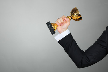 Businessman holding golden cup trophy