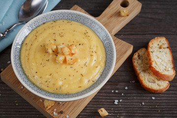 Bowl of zucchini and cauliflower cream soup on wooden table. Hea