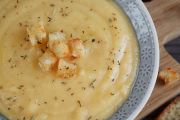 Bowl of zucchini and cauliflower cream soup on wooden table. Hea