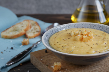 Bowl of zucchini and cauliflower cream soup on wooden table. Hea