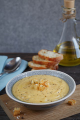 Bowl of zucchini and cauliflower cream soup on wooden table. Hea