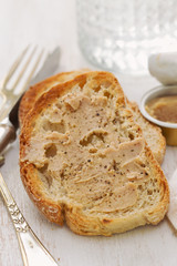 bread with pate and glass of water on white wooden background