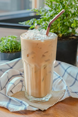 Iced Coffee  with Dark brown straw on decorative background.