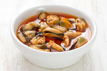 mussels with sauce in white dish on white background