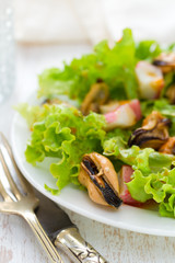 salad with mussels on white dish on white background