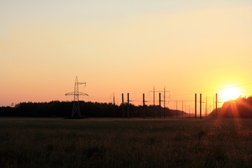 Fototapeta na wymiar electric and solar energy in the natural landscape/ power line running over the horizon at sunset in the summer 