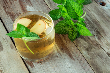 Glass of cool green tea with mint and apples