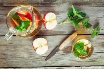 Glass and carafe of green tea with mint and apples