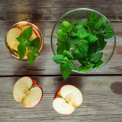 Green tea, a bowl with mint and cut apple