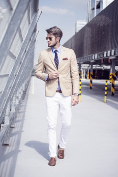 Handsome man in bright suit against the city