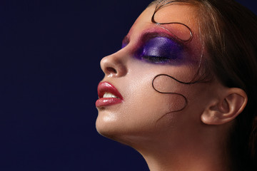 Close-up portrait of girl with purple makeup on eyes