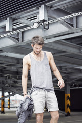 Young man dressed in sportswear on a city background