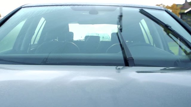 Slowmotion the view from outside on the car and the turn on windscreen wipers