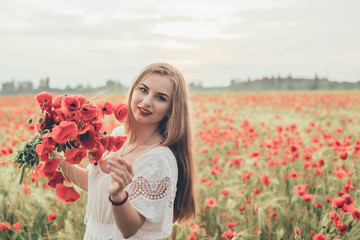 Naklejka premium young caucasian female in poppy field enjoying the sunset