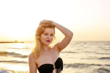 young beautiful female on beach enjoying vacation during sunset or sunrise