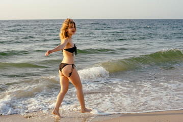 Fototapeta na wymiar young beautiful female on beach enjoying vacation during sunset or sunrise 