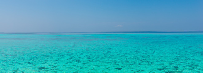Ocean view. In the sky a few clouds. Turquoise water of the lagoon.