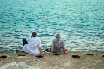 Fototapeta premium Two Men Sitting by the Sea