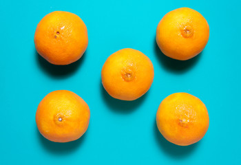 Fresh orange fruits and juice on blue table.