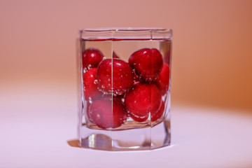 Cherries in glass of water with air bubbles
