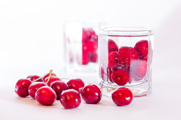 Cherries in glass and a handful of cherries beside