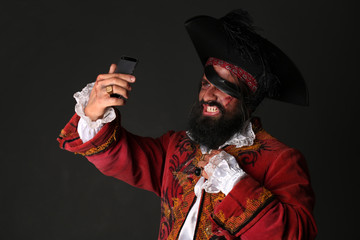 Man in a pirate costume with mobile phone, makes self