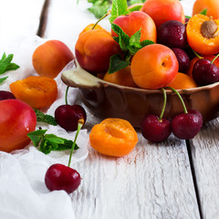 Ceramic bowl with organic ripe apricots and cherries