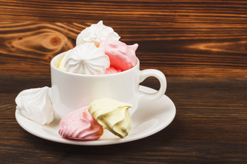 Fototapeta na wymiar Cup with light pink meringues