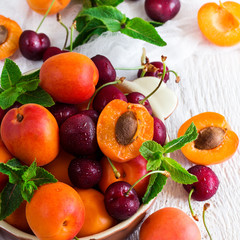 Ceramic bowl with organic ripe apricots and cherries