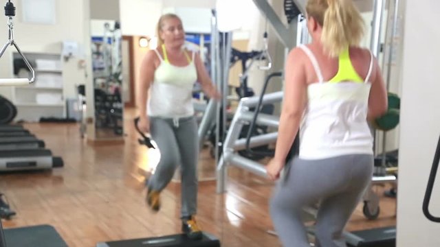 Blonde woman exercising workout fitness aerobic exercise in the gym