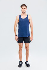 Full length portrait of a man in sportswear standing isolated