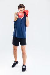Portrait of a man hitting at camera in boxing gloves