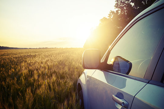 Car In The Field On Background Of Magnificent Sunset