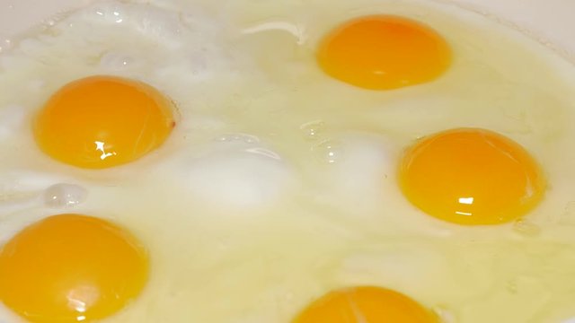 Eggs frying on hot oil 4K 2160p UHD video - Fresh organic eggs in ceramic frying pan and hot oil 4K 3840X2160 UHD footage 