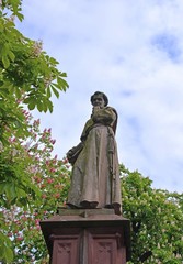 Fototapeta na wymiar Nahaufnahme von der Brunnenfigur am Rathausplatz umrahmt von bluehenden Kastanienbäumen, Freiburg Breisgau 
