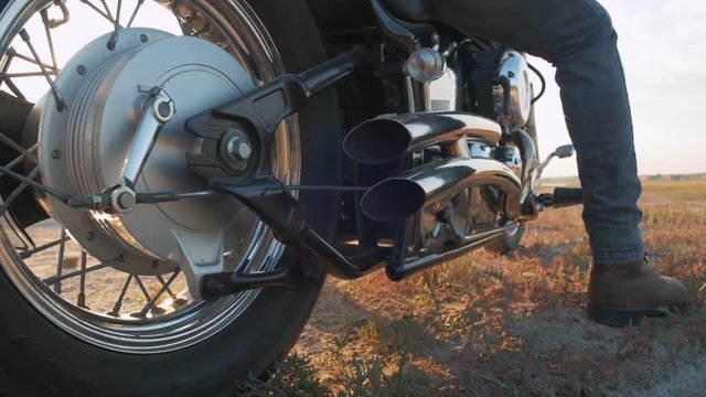 Close up shot of motorcyclist starting to drive his motorbike on the road