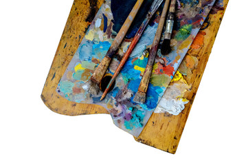 paints and brushes on a wooden palette