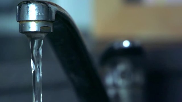 Slowmotion flood of water flows from tap