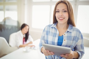 Businesswoman holding tablet with colleague 