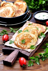 Pancake with parsley and spring onions on a wooden background