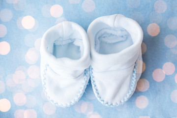 close up of baby bootees for newborn boy on blue